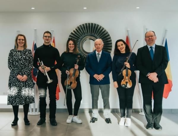 Photograph of 6 people stood together. Three musicians are pictured holding instruments, and between them are two members or CBSO staff along with Sir Peter Rigby.