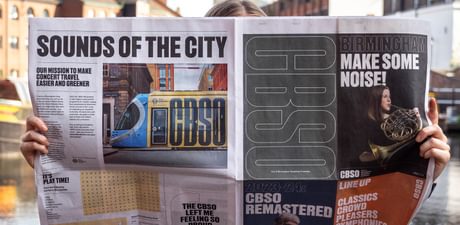 Photograph of somebody reading the CBSO Newspaper beside the canals in Birmingham
