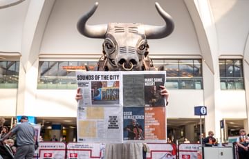 Photograph of Ozzy the Bull reading the CBSO Newspaper