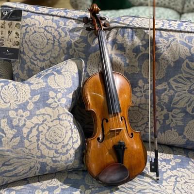 Violin on blue patterned sofa