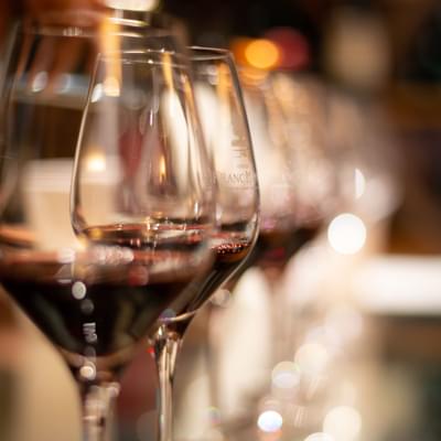 Photograph of red wine glasses.