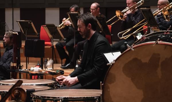 Photograph of Matthew Hardy playing the timpani on-stage at Symphony Hall