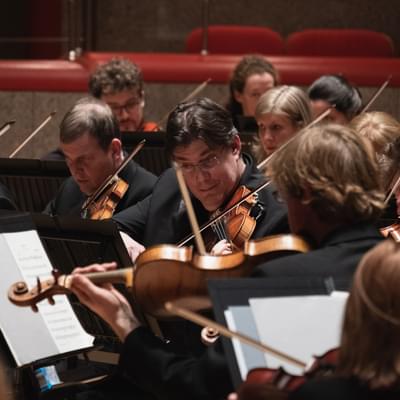 Photograph of Peter Campbell-Kelly playing in the violin section in Symphony Hall