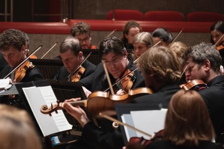 Photograph of Peter Campbell-Kelly playing in the violin section in Symphony Hall