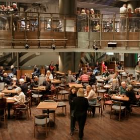 People sit and stand talking in the Jennifer Blackwell Performance Space