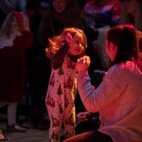 Photograph of a young girl dancing with her mother at a Notelets performance