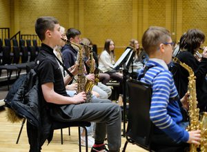 Photograph of a group of young saxophonists rehearsing