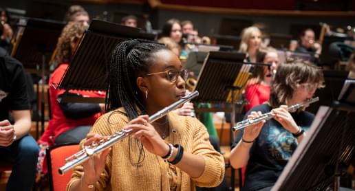 Photograph of a teenage girl playing the flute in a Project Remix rehearsal