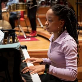 Photograph of a teenage girl playing the piano