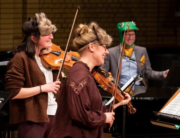 Photograph of Charlotte Skinner and Jessica Tickle playing whilst wearing animal masks during a Relaxed Concert