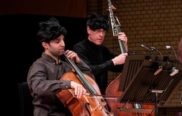 Photograph of Miguel Fernandes playing the cello whilst wearing an animal mask at a Relaxed Concert