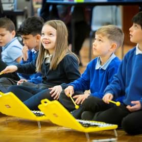 Photograph of children in school uniform playing on glockenspiels
