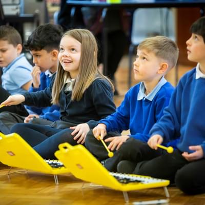 Photograph of children in school uniform playing on glockenspiels