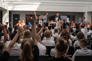 Photograph of children waving their arms in the air during a performance at Shireland CBSO Academy