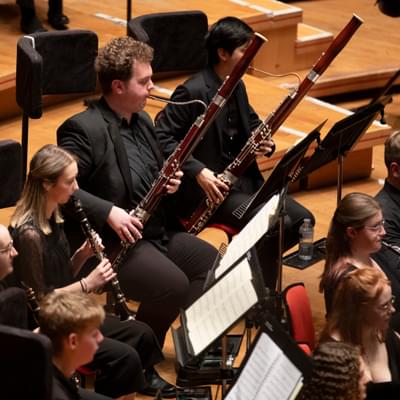 Two bassoons, clarinettist and oboists playing on stage