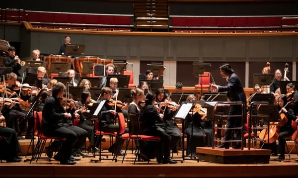 Orchestra being conducted on a stage