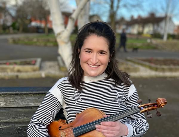 Photograph of Jessica Tickle smiling and holding her viola