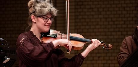 Photograph of Charlotte Skinner performing whilst wearing a cat mask as part of a Relaxed Concert