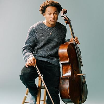 Photograph of Sheku Kanneh-Mason holding his cello.