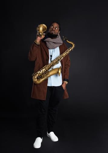 Photo of Soweto Kinch holding two saxaphones