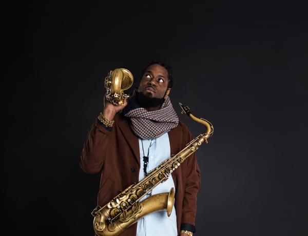Photo of Soweto Kinch holding two saxaphones